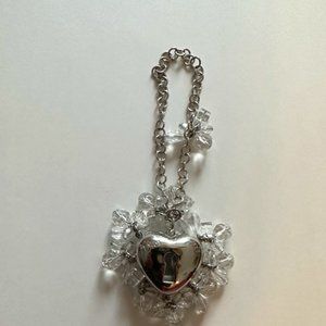 Dior on silver heart chain.  Inside pink lip gloss.